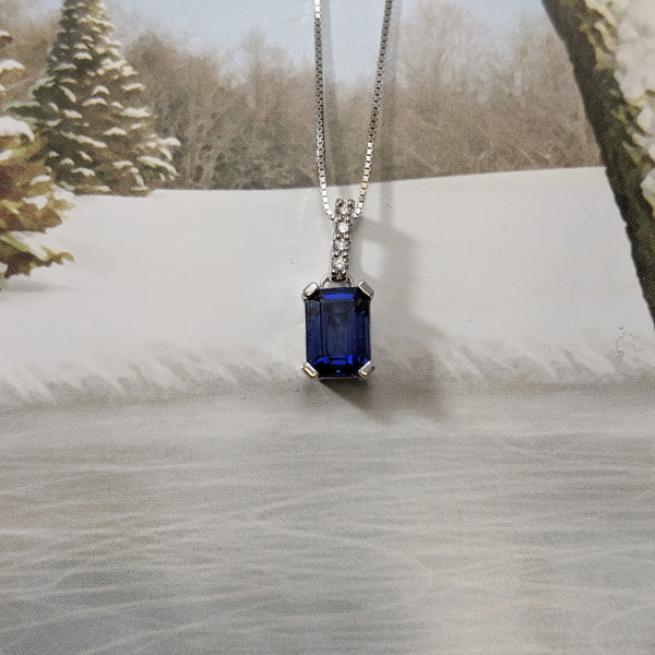 Beautiful and affordable! Emerald cut created Sapphire has a beautiful vibrant blue color! Accented with four round brilliant cut diamonds. Chain sold separately. $250.00
