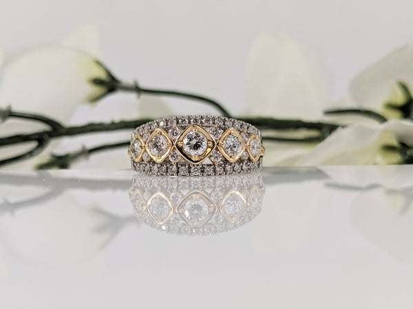 This 14K white and yellow gold diamond band is set with 1.00cttw in round brilliant cut diamonds. The combination of the white and yellow gold draws the eye to this stunning piece. Measuring at 9.00mm at the center, this ring tapers to a comfortable 3.00mm shank. Finger size 7  $2500.00