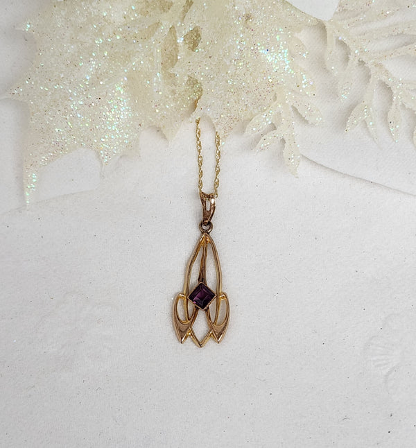 This lovely Lavalier is constructed of 10k yellow gold and set with a single 3mm purple stone. The pendant measures 25mm in length and 9mm in width. The pendant is hung on an 18" inch 14k yellow gold whisper chain