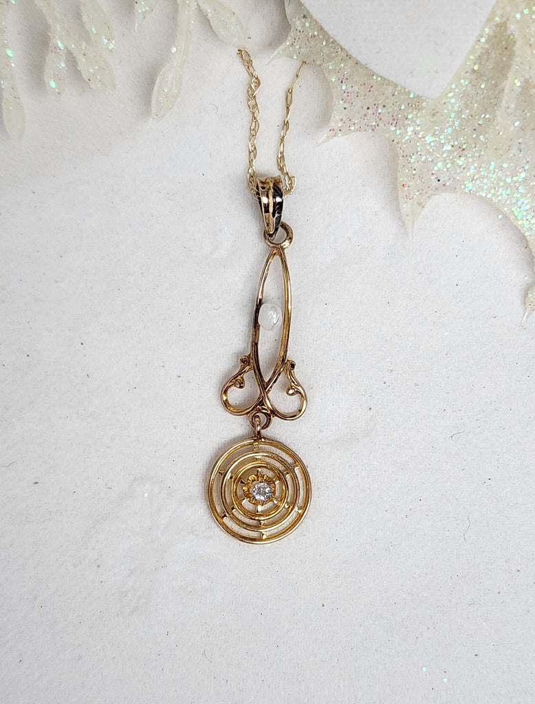 This darling lavalier is made from 10k yellow gold is set with a single baroque like pearl and single .019ct natural mined old mine cut diamond. This lavalier lovingly shows it's age through it's vast colors of patina. Hung from an 18" inch light whisper chain, the lavalier measures 36.00mm in length.