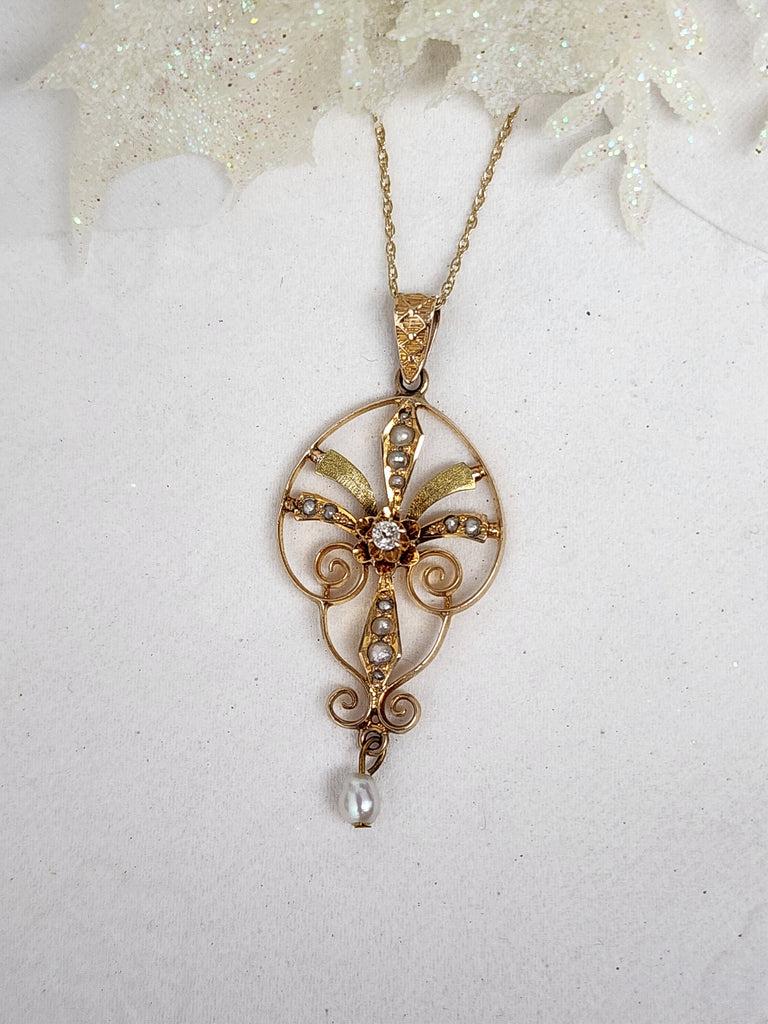 This stunning Lavalier is made from 10k yellow gold. It contains (13) thirteen pearls and a single .04ct natural mined old mine cut diamond. The lavalier measures 42mm from the top of the bail to the bottom of the pearl and 18mm in width. The pendant is hung on a 16" inch 14k yellow gold whisper chain. The lavalier is not stamped but preliminary acid testing indicates it is 10k yellow gold

*Disclaimer. This is an estate piece. Diamond was sized by measurement only and not by scale weight. Diamond weight is