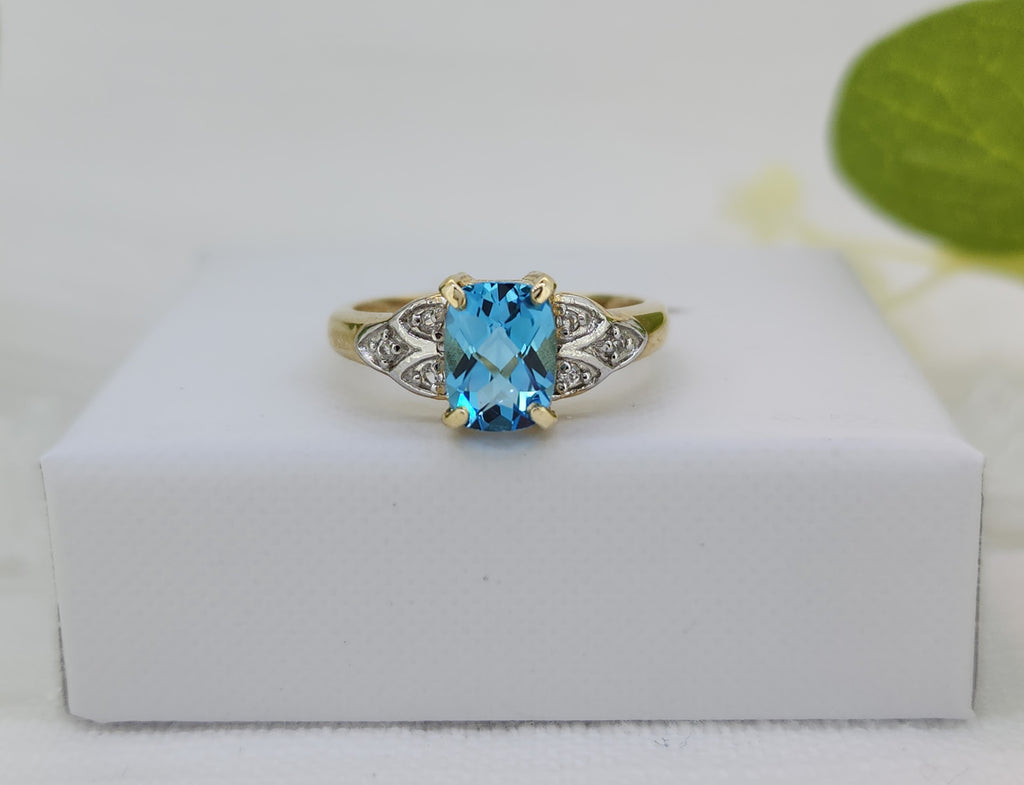 Refined with a touch of brilliance, this ring features an 8×6mm fancy checkerboard-cut Swiss blue topaz. The center stone is accented by .03 carat total weight of natural mined diamonds, adding subtle shimmer and contrast.
Crafted in 14K yellow and white gold, the design offers beautiful mixed-metal appeal. The ring measures 7.87mm at the top and tapers to a slender 1.90mm shank, creating a balanced and comfortable profile. With a total weight of 3.1 grams