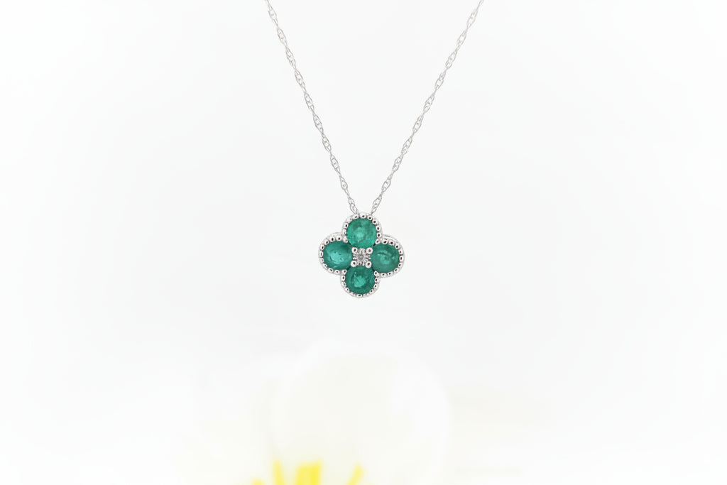 This elegant pendant is crafted in 14k white gold and features natural emeralds totaling .50 carat total weight, arranged in a graceful clover-inspired design. The rich green gemstones are accented by a .01 carat round brilliant cut natural mined diamond at the center, adding a subtle touch of sparkle.

The pendant is suspended from an 18-inch 14k white gold Singapore chain, offering a delicate shimmer and comfortable everyday wear.
