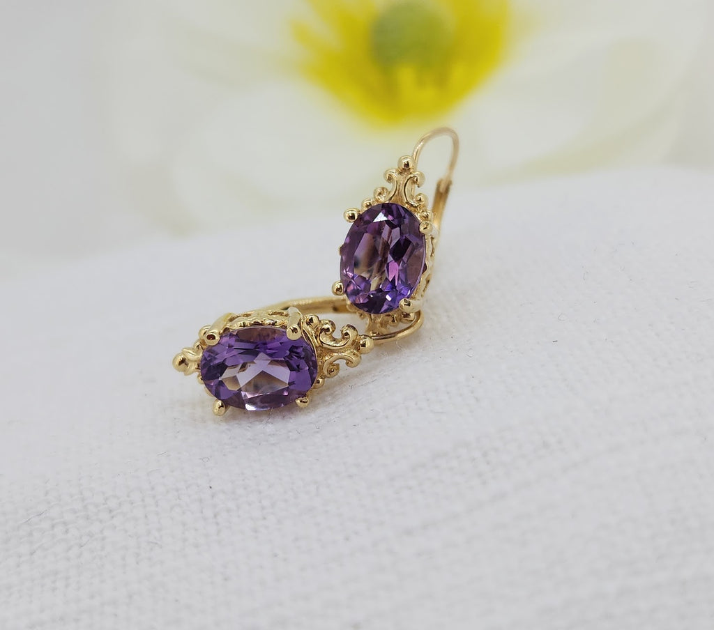 These elegant earrings are crafted in 14k yellow gold and feature rich violet amethyst gemstones measuring 8 × 6 mm each. The oval-cut amethysts are securely set and accented by delicate gold detailing, giving the design a timeless, slightly vintage-inspired feel. Finished with comfortable leverback closures, these earrings offer both beauty and ease of wear. Total weight of the earrings including the stones is 2.50grams