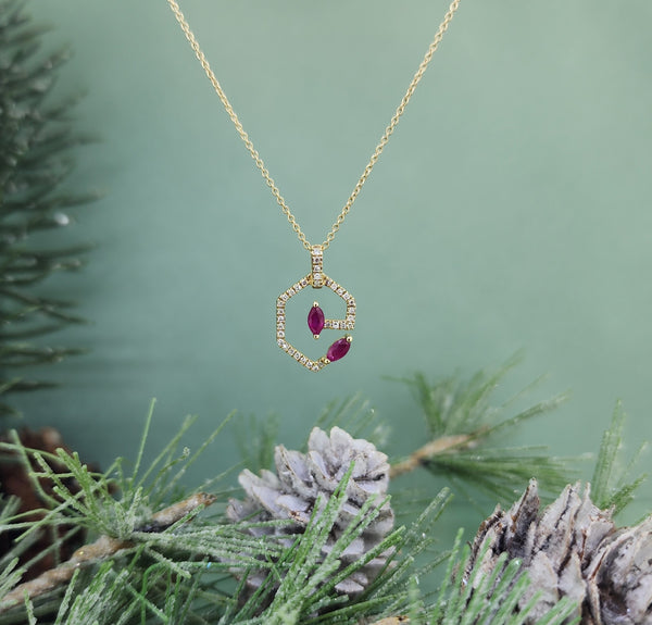 Stunning 14k yellow gold pendant set with (2) two lovely marquise cut natural Rubies accented with .10cttw in natural round brilliant cut diamonds. The chain is adjustable at 16" inches, 17" inches and full length of 18" inches! So versatile! Perfect size pendant measuring at 17.97mm in length and 10.67mm in width. Beautiful contemporary piece!&nbsp;