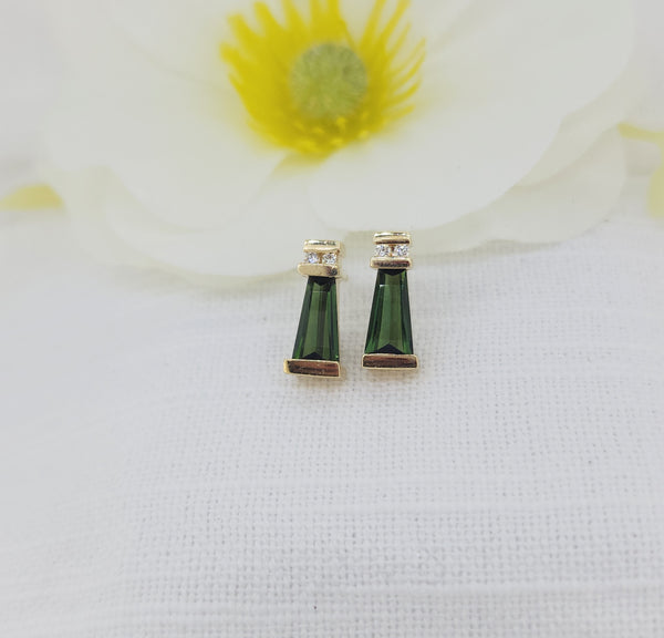 These elegant earrings are crafted in 14k yellow gold and feature fancy-cut green tourmalines measuring 8.50 × 4.50mm, showcasing rich, deep green color. Each tourmaline is accented by natural mined diamonds totaling .06 carat total weight, adding a subtle touch of sparkle.
The earrings measure 14.26mm in length and 6.00mm in width and are designed with regular posts and backs for secure, comfortable wear. Total weight of the earrings including the stones&nbsp;4.20 grams.