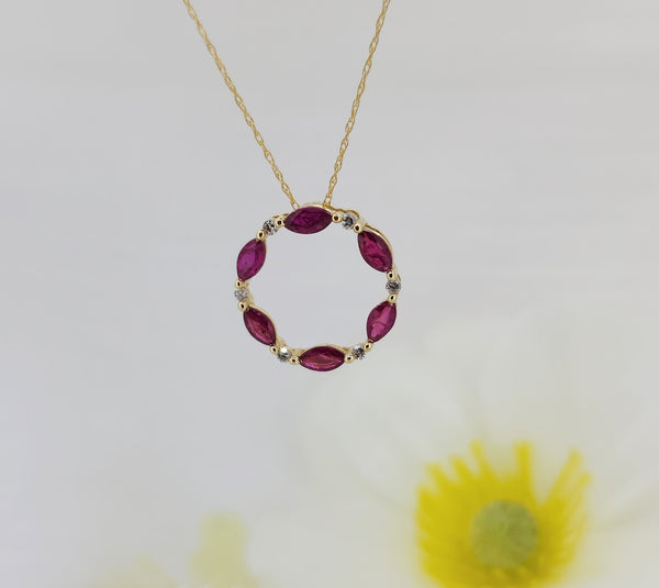 The pendant is constructed of 14k yellow gold and is set with (6) six natural rubies that have a combined carat weight of .75cts and are accented by (6) six natural mined round brilliant cut diamonds with a combined carat weight of .10ctw. This beautiful pendant is hung on a 14k yellow gold 18" inch whisper chain with a spring ring clasp. The circle measures 16.50mm