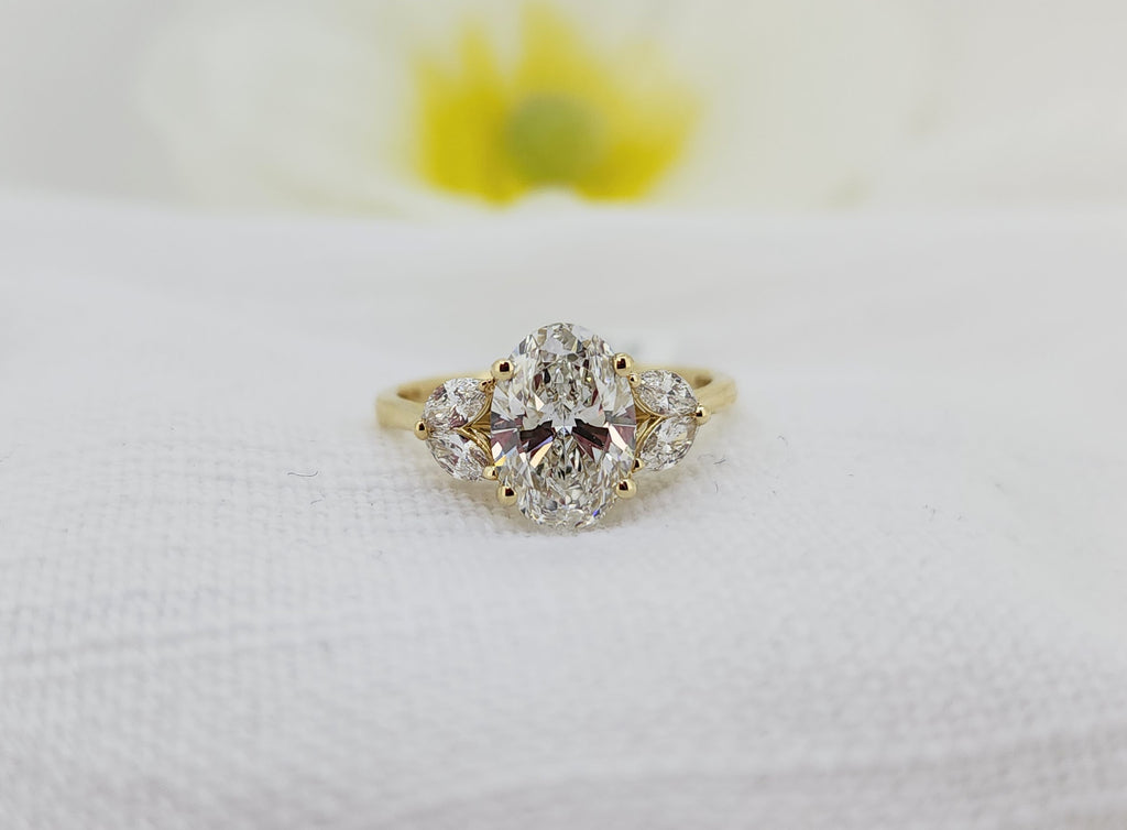 Make a statement with this dazzling 14k Yellow Gold Diamond Ring, designed to capture light from every angle. At its center is a stunning 2.00 carat Created (lab) oval cut diamond, surrounded by .25 carat total weight of Created (lab) marquise cut diamond accents that enhance its brilliance and presence.
Set in rich 14k yellow gold, this ring offers the beauty and sparkle of a classic diamond design with a modern, ethical approach. A perfect choice for an engagement ring, anniversary gift, or a timeless ad
