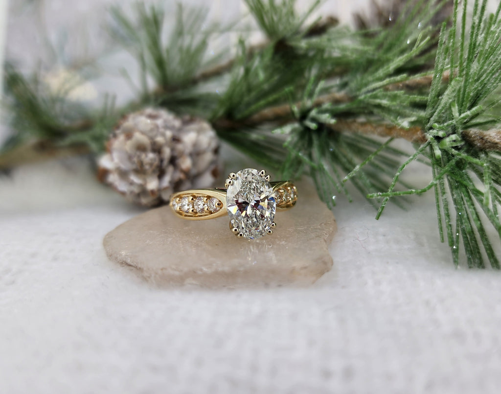 This is an extremely well built ring. The mounting is constructed of 14k yellow gold and weighs 7.8grams. Set in the center of this lovely ring is a 2.61ct Lab oval diamond. F in color, VS1 in clarity, set in a 14k white gold head. Accenting the center diamond is .83cttw in round brilliant cut natural mined diamonds, (5) five set on each side of the center diamond. Stunning ring! USA finger size 7.50