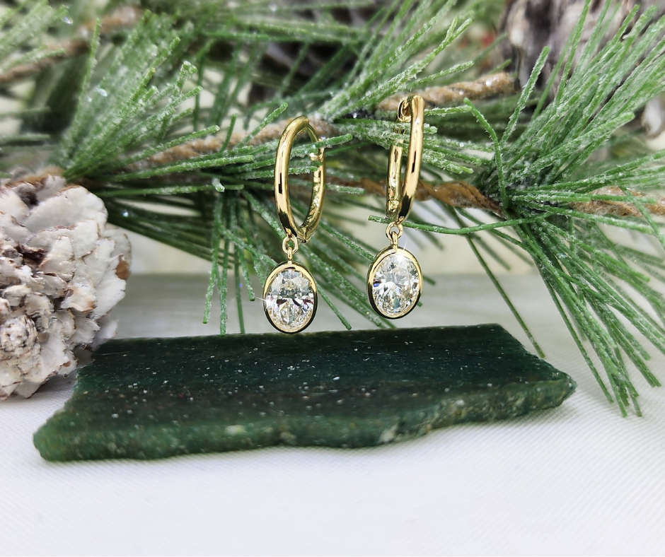 Classic. Beautiful and classic. These beauties are made from 14k yellow gold and each earring is set with a .75ct Lab oval diamond. Hinged hoop for easy and comfortable wear. 1.50cttw in diamonds.