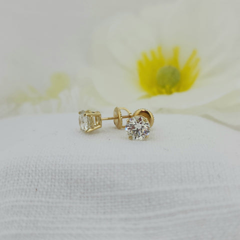 These two stunning diamonds are set in 14k yellow gold mountings with screw posts and matching backs. One diamond is a 1.06ct round brilliant cut natural mined with an IGI report grade as H color I1 clarity and excellent cut grade. The second diamond is a 1.00ct round brilliant cut natural mined with an IGI report grade of I color I'1 clarity and excellent cut grade. Total diamond weight of the set is 2.06ctw (carat total weight) Beautiful set! Make them yours today!