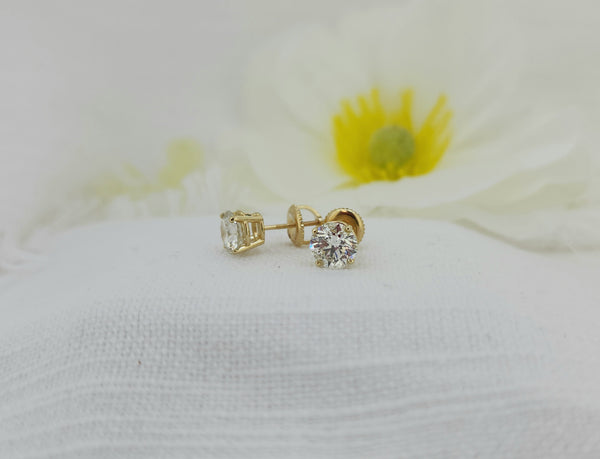 These two stunning diamonds are set in 14k yellow gold mountings with screw posts and matching backs. One diamond is a 1.06ct round brilliant cut natural mined with an IGI report grade as H color I1 clarity and excellent cut grade. The second diamond is a 1.00ct round brilliant cut natural mined with an IGI report grade of I color I'1 clarity and excellent cut grade. Total diamond weight of the set is 2.06ctw (carat total weight) Beautiful set! Make them yours today!