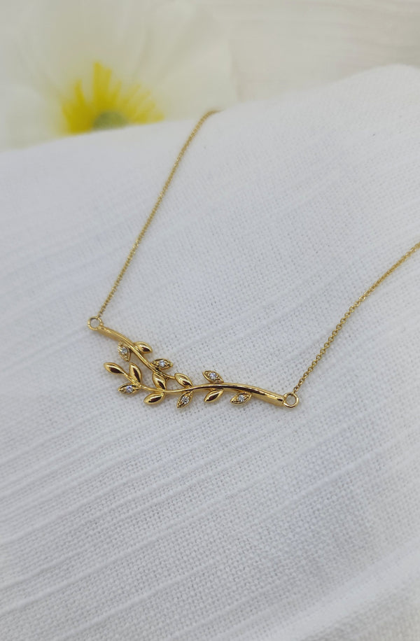 Delicate and graceful, this 14k yellow gold leaf necklace is a timeless symbol of natural beauty. Crafted in warm, rich gold and weighing 3.6 grams, the design features a softly curved branch adorned with leaf motifs, each accented by round brilliant cut natural mined diamonds totaling .05 carat total weight.

 Finished with an adjustable chain that wears beautifully at 16, 17,18 inches