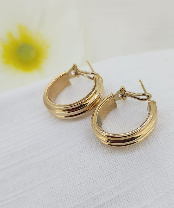 These classic hoop earrings are crafted in 14k yellow gold and feature a softly ribbed design that adds subtle texture and dimension. Made in Italy, they are lightweight and comfortable, making them an ideal choice for everyday wear while still offering a bold, polished look.

Details:
Metal: 14k yellow gold
8.00mm in width
Style: Ribbed hoop earrings
Total weight: 3.90 grams
Closure: Omega back
Origin: Made in Italy
Condition: Estate - Previously loved
