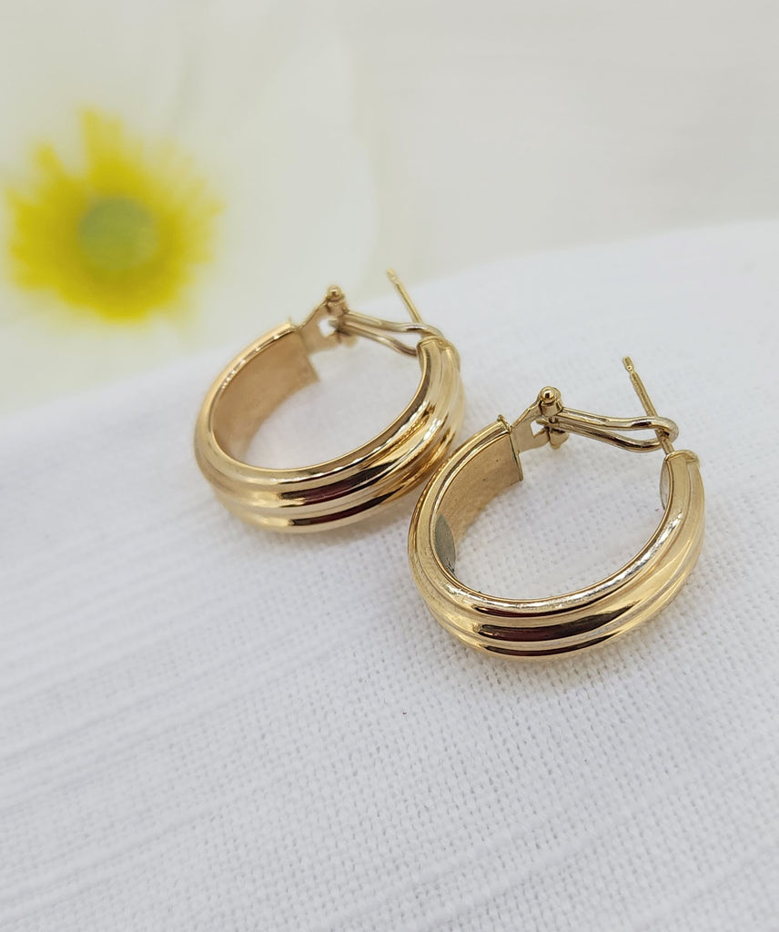 These classic hoop earrings are crafted in 14k yellow gold and feature a softly ribbed design that adds subtle texture and dimension. Made in Italy, they are lightweight and comfortable, making them an ideal choice for everyday wear while still offering a bold, polished look.

Details:
Metal: 14k yellow gold
8.00mm in width
Style: Ribbed hoop earrings
Total weight: 3.90 grams
Closure: Omega back
Origin: Made in Italy
Condition: Estate - Previously loved
