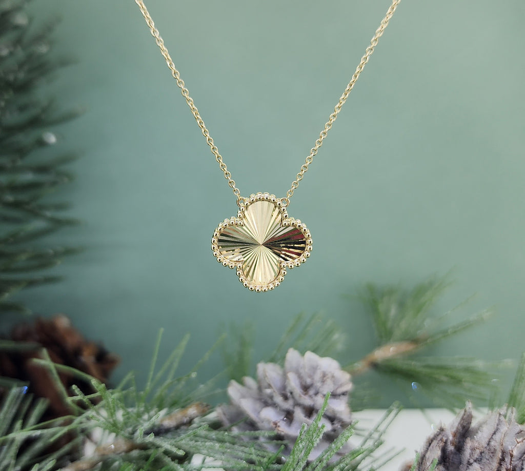 Stunning 14k yellow gold fluted clover necklace attached on each side to an 18" inch adjustable chain. The clover measures 14.45mm wide and 14.67mm high. Reversible! Wear with high polish side out or fluted. Nice heavy piece weighing in at 3.2grams