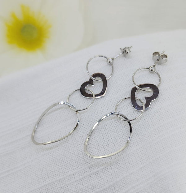 14k White Gold Heart Dangle Earrings

These romantic dangle earrings are crafted in 14k white gold and feature a graceful cascade of open circles accented by delicate heart motifs. Designed with beautiful movement and a modern yet sentimental feel, they make a meaningful statement while remaining light and comfortable to wear.
Details:
Metal: 14k white gold
Style: Dangle earrings with heart accents
Total weight: 2.80 grams
Length: 50.00mm from the ball stud to the bottom dangle

Width: 16.75mm (largest