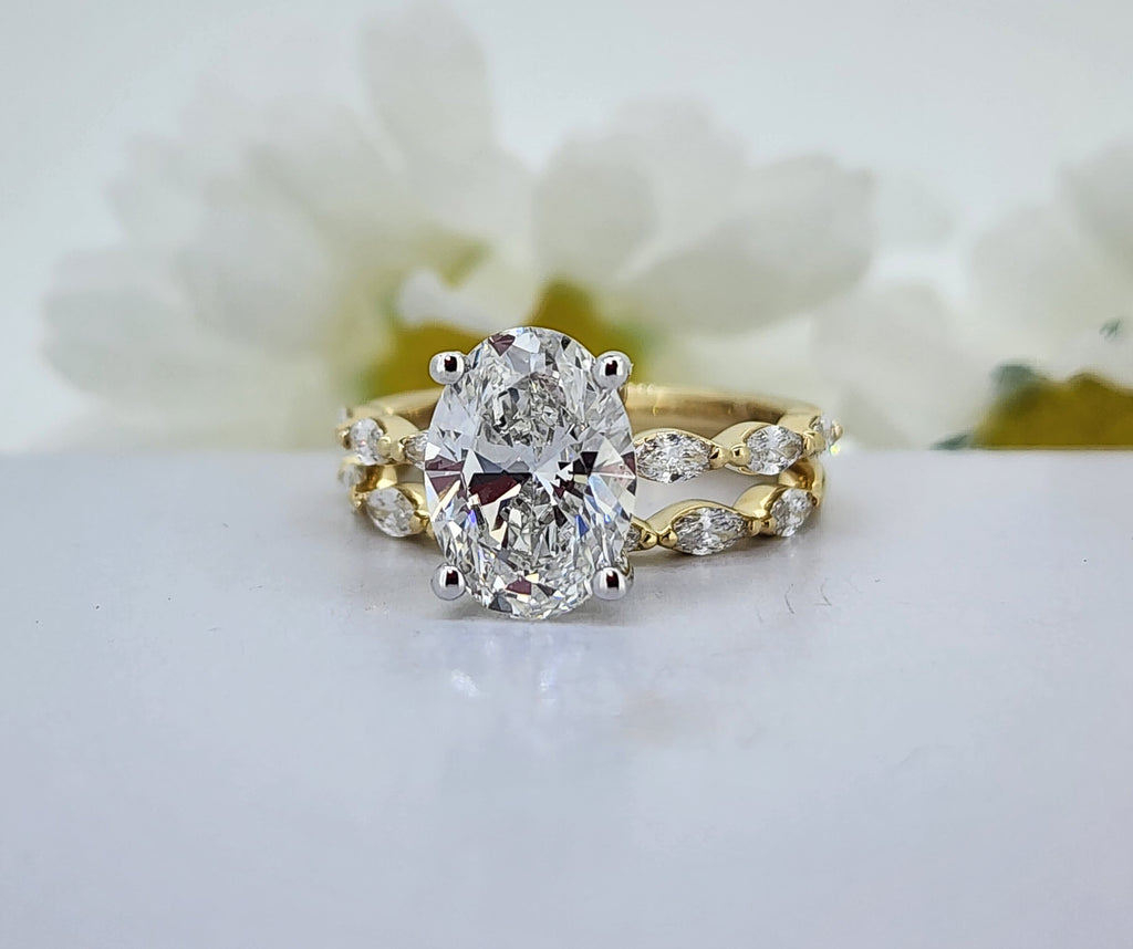 What a fabulous wedding set! The mounting is crafted in 14k yellow gold. The ring boasts a stunning 3.09ct Lab created center diamond that is E in color and VS1 in clarity. On each side of the center are three lab created marquise cut diamonds with a combined weight of .35cttw. The matching wedding band is set with seven lab created marquise cut diamonds with a combined diamond weight of .40cttw. Total diamond weight of this ring including the center diamond is 3.84cttw. Center diamond has an IGI report 