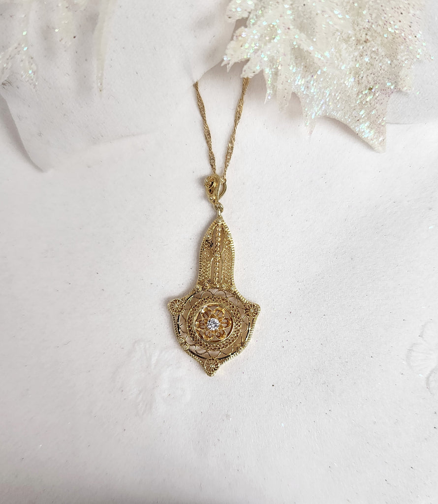 This lovely intricate designed Lavalier is made from 14K yellow gold.&nbsp; The lavalier measures 1.40" inches in length and contains (1) one .035ct round natural mined diamond. The pendant is hung on an 18" inch 14k yellow gold singapore chain

*Disclaimer. This is an estate piece. Diamond is sized by measurements only and not by scale weight. Size is approximate