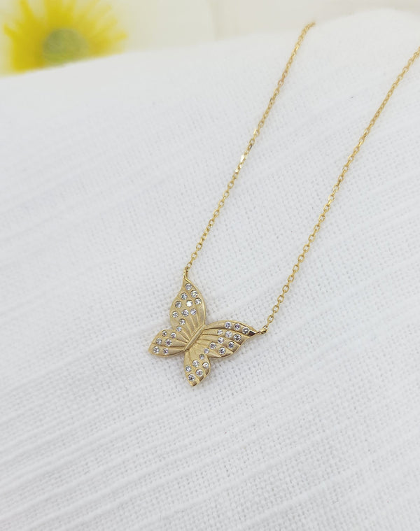 Graceful and full of meaning, this 14k yellow gold butterfly necklace is a beautiful symbol of transformation and freedom. Crafted in rich yellow gold and weighing 3.00 grams, the butterfly design is accented with 34 round brilliant cut natural mined diamonds, totaling .15 carat total weight, adding luminous sparkle across each delicately detailed wing.

The diamonds are thoughtfully set to enhance the texture and movement of the butterfly, creating a piece that catches the light from every angle. 