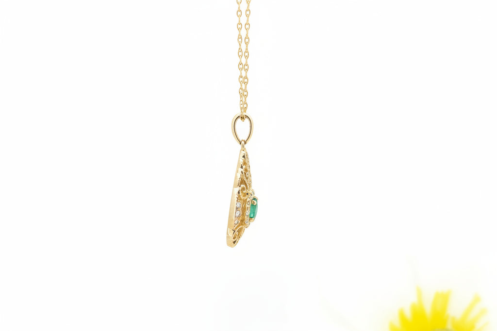 This elegant pendant is crafted in 14k yellow gold and features a .37 carat round faceted natural emerald at its center, surrounded by .18 carat total weight of natural mined diamonds for added brilliance. The openwork design showcases graceful detailing that allows light to enhance the gemstones’ sparkle.
The pendant measures 22.87mm in length and 11.75mm in width and is suspended from an 18-inch 14k yellow gold Singapore chain, offering a refined and feminine look.
A beautifully detailed piece that comb