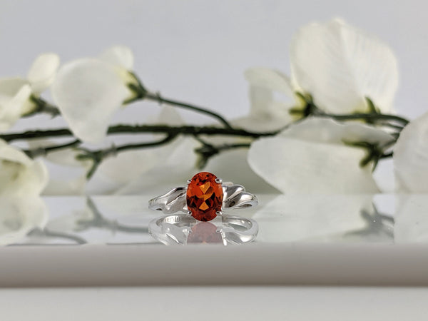 Classic simple setting holding an 8x6mm oval created orange sapphire. 10L white gold. Finger size 6. $415.00