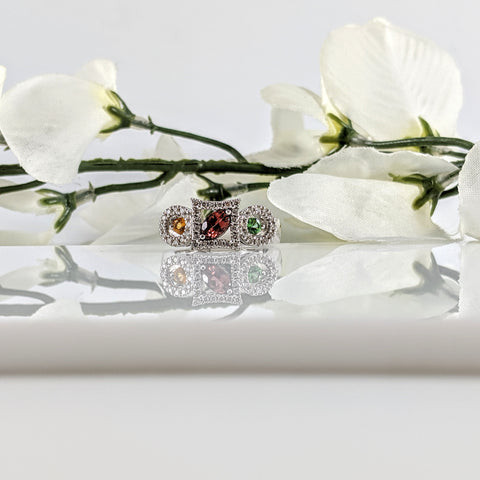 Constructed of 14K white gold, this ring is solid and features a great color combination and stone cuts. The center stone is a marquise cut Pink Tourmaline set diagonal in a square halo. On one side is a round cut Tsavorite Garnet and on the other side is a round cut Citrine. All gemstones have a halo of diamonds around them. If you are looking for something unique, this is certainly the ring for you. Finger size 7. $1200.00 