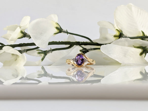 Constructed of 14K yellow gold this lovely ring features a 7x5mm oval amethyst and .03cttw in round brilliant cut diamonds. Simple and elegant. Finger size 7. $295.00