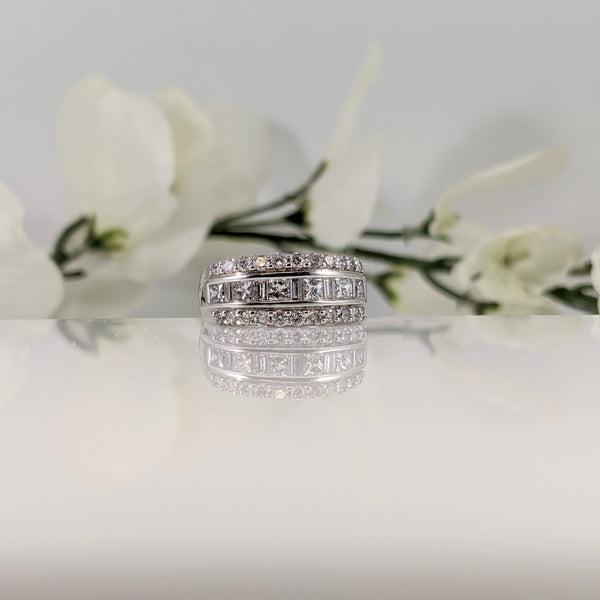 This stunning 14K white gold ring features 1.50cttw in diamonds. A mixture of princess cut and baguette cut center row diamonds create the perfect combination of shimmer and shine while the outer row of round brilliant cut diamonds add the brilliance to make this a sure love at first site ring.  $2500.00