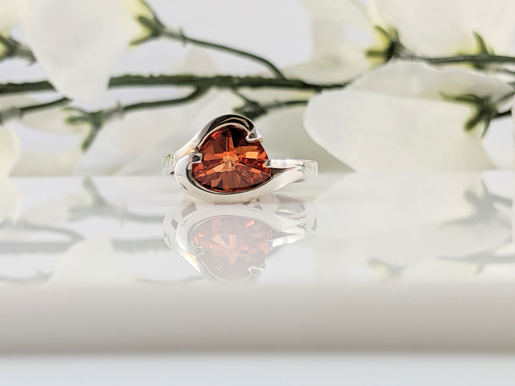This unique ring was made by a company called Strellmans out of Oregon. Center stone is 10x8mm custom cut stone set in sterling silver mounting. Finger size 6.5.  $315.00
