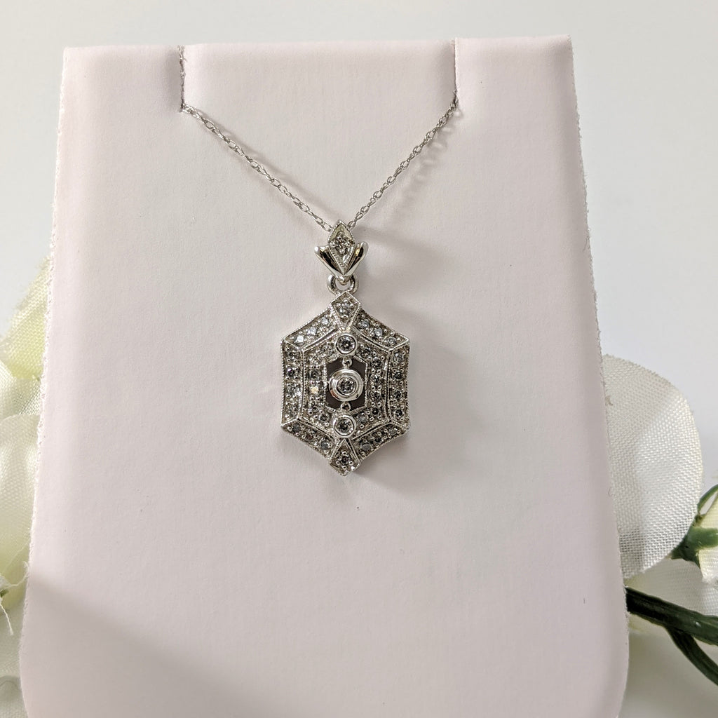 Stunning 14K white gold and diamond vintage inspired pendant!  .30cttw in round brilliant cut diamonds sparkle and draw the eye to this lovely pendant. Hung on an 18" inch 14k light white gold chain. Only $450.00!