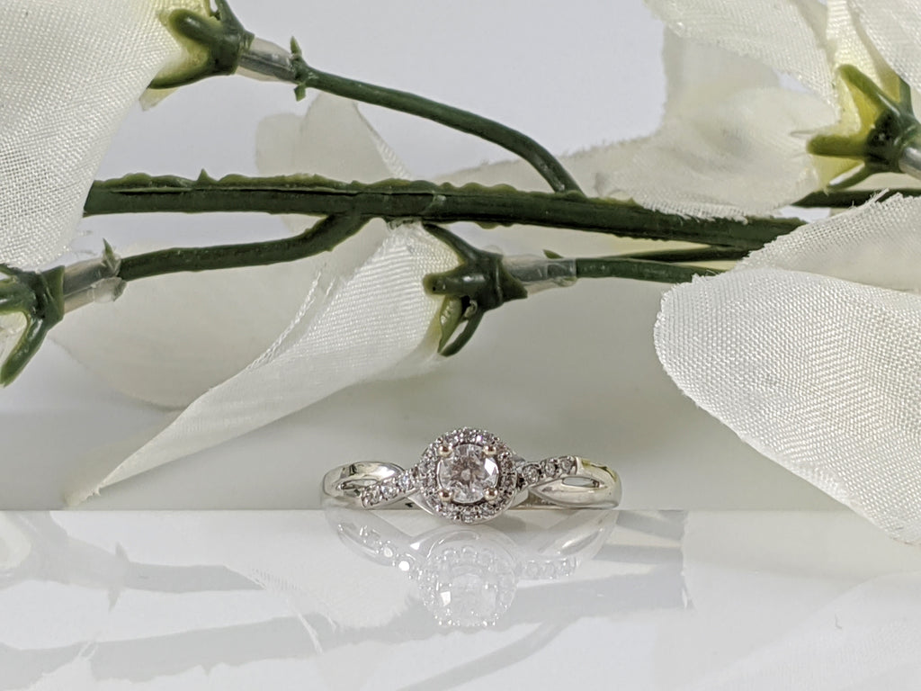 Fancy and affordable this 10k white gold and diamond engagement ring contains a .22ct center diamond and .11cttw in additional accent diamonds. Finger size 7. $750.00